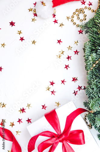 Flat lay  Top view Christmas composition isolated on white background. Natural green pine wreath  gift box with red fabric tape  spiral ribbon  gold stars confetti. Xmas . Decor table.