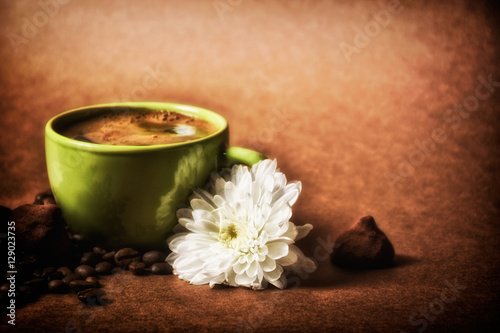 still life. warm cup of coffee on brown background. Dramatic interpretation. Low key, dark background, spot lighting, and rich Old Masters colors.