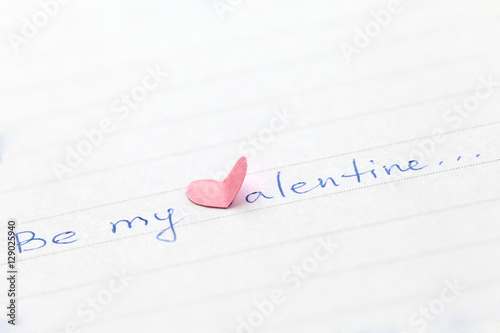 Handwritten phrase "Be my Valentine" with heart. Shallow depth of field.