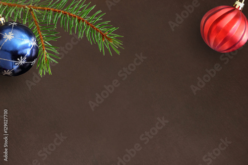 Dark background with Christmas fir branch, blue and red wavy ball photo