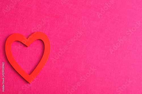 Valentine's Day. A red heart isolated against a pink background