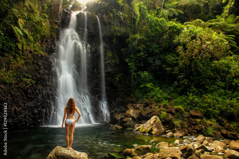 Fototapeta premium Młoda kobieta w bikini pozyci Środkowymi Tavoro siklawami w Bo