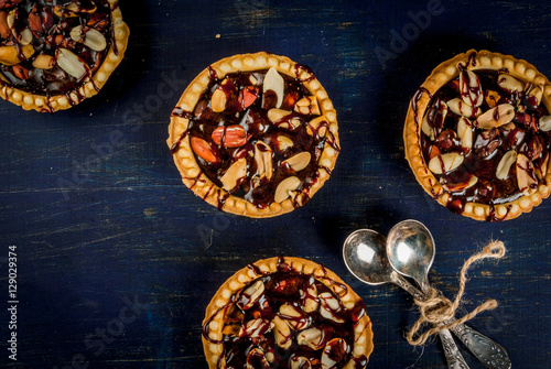 Mini tarts with nuts and caramel on a dark blue background  top view  copy space.