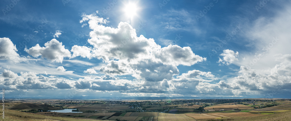 Sun rays in the cloudy sky over fields and villages. Sun rays in the cloudy sky over fields and villages.