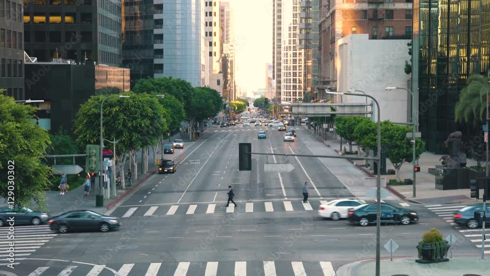 Traffic and people cross at a busy intersection in Downtown Los Angeles