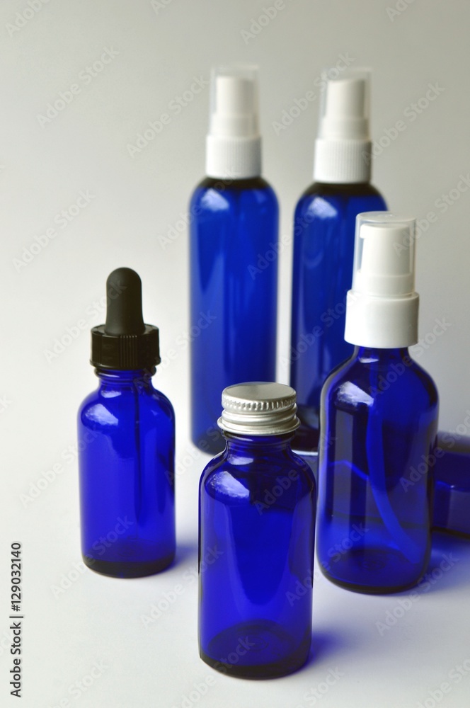 Group of dark blue glass bottles for cosmetic lotions, serums, oils and liquids
