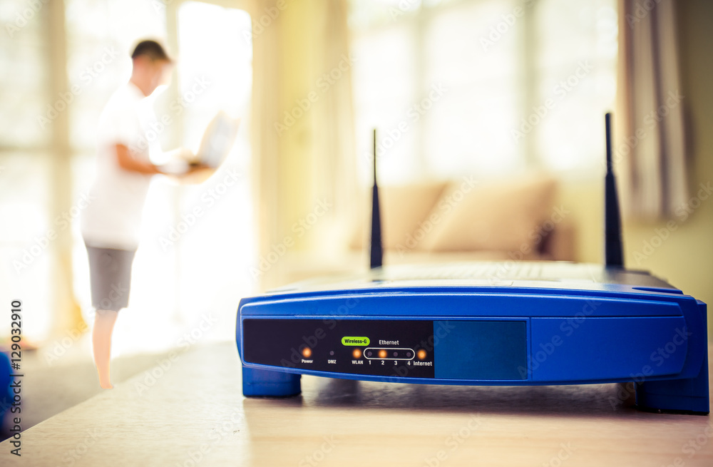 closeup of a wireless router and a young man using Laptop and notebook  computers on living room at home with a window in the background Stock  Photo | Adobe Stock