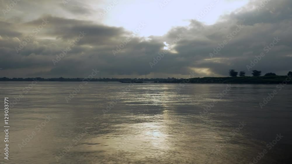 Cloudy sunrise over the mekong river (shot from a moving boat) Cloudy sunrise over the mekong river (shot from a moving boat)