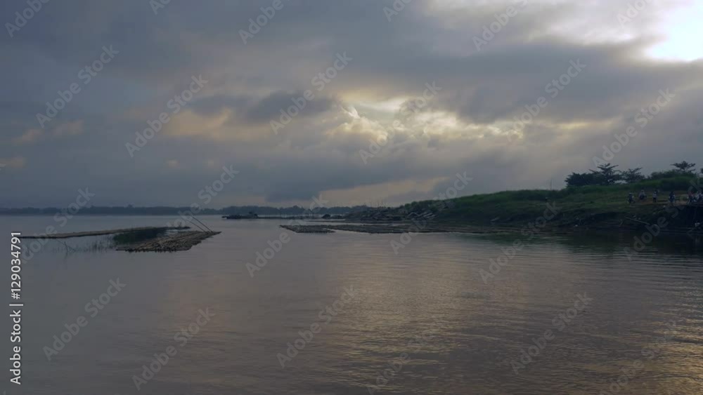 Dark cloudy sunrise over river (shot from a boat reaching riverbank) Dark cloudy sunrise over river (shot from a boat reaching riverbank)