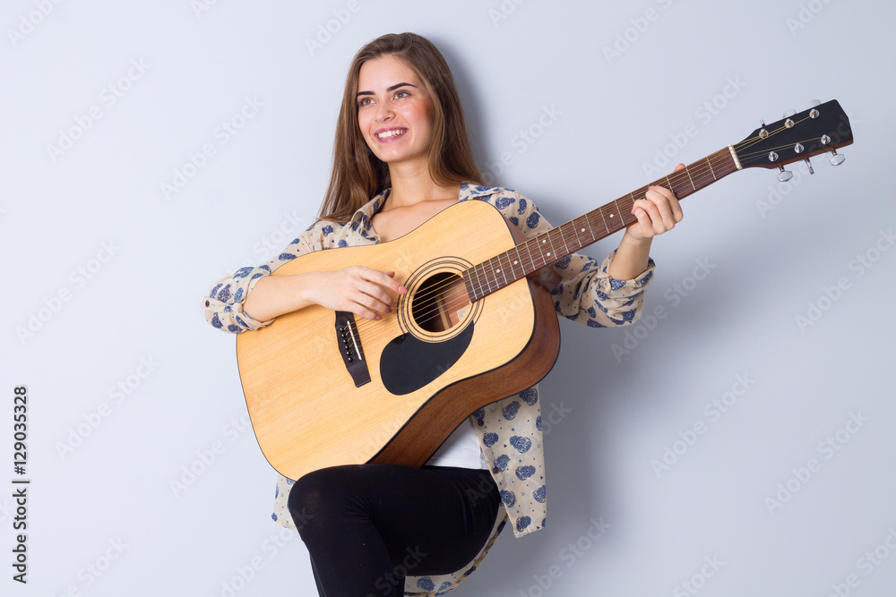 Fototapeta premium Young woman holding a guitar 