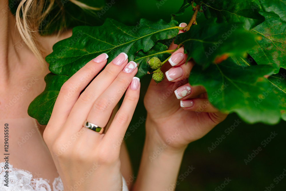 Fototapeta premium Wedding rings and beautiful manicure bride