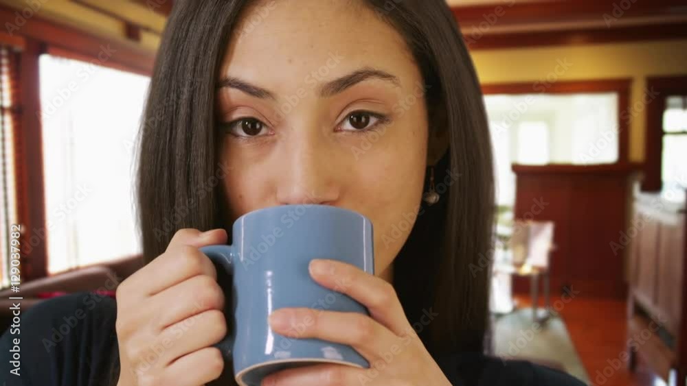 A close-up portrait of a Hispanic woman drinking coffee A close-up portrait of a Hispanic woman drinking coffee