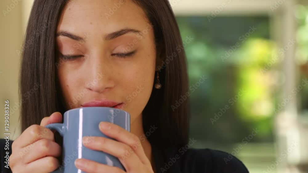 A Hispanic woman drinks her morning coffee A Hispanic woman drinks her morning coffee