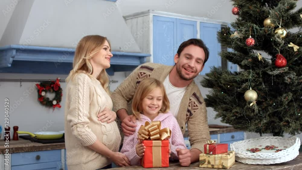 Happy father kissing his daughter and hugging his family while crlebrating New Year or Christmas at home all together. New Year or Christmas concept. Happy father kissing his daughter and hugging his family while crlebrating New Year or Christmas at home all together. New Year or Christmas concept.