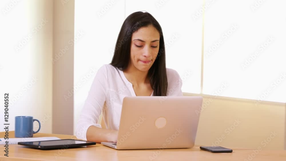 A Latina businesswoman deals with problems on her laptop at work A Latina businesswoman deals with problems on her laptop at work