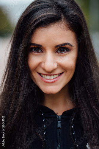 Young beautiful brunette fitness woman looking at camera and smiling, closeup.