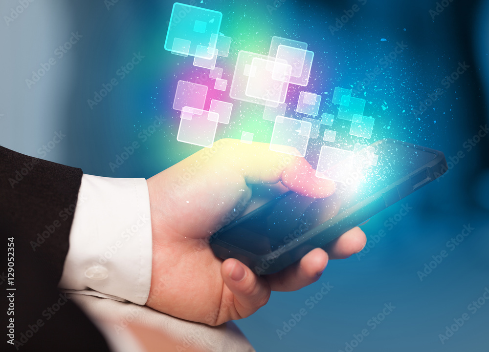 Hand holding smart phone with abstract glowing squares Hand holding smart phone with abstract glowing squares