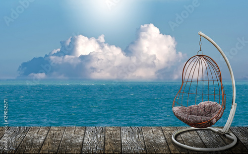 hanging chair on the wooden balcony with sea view © NAMPIX