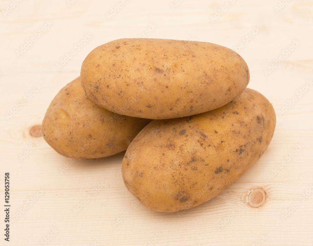 Fresh potatoes on a wooden background Fresh potatoes on a wooden background
