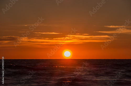 Fiery sunrise at Italian beach. Summer season. Emilia Romagna region. Adriatic sea. Italy