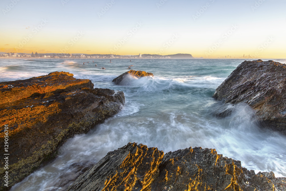 Clear skies sunrise with ocean current over the rocks at Currumbin Rock Gold Coast