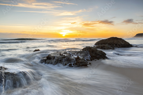 Sunrise with ocean pouring over the rocks. Gold Coast Australia.