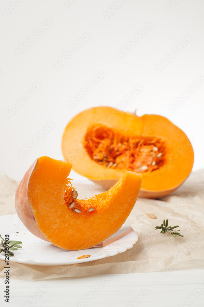 raw chopped pumpkin on white wooden background