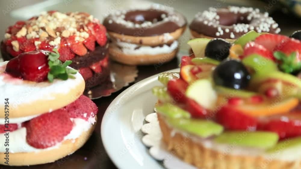 Assorted fruit tartlets, donuts and pieces of cakes Assorted fruit tartlets, donuts and pieces of cakes