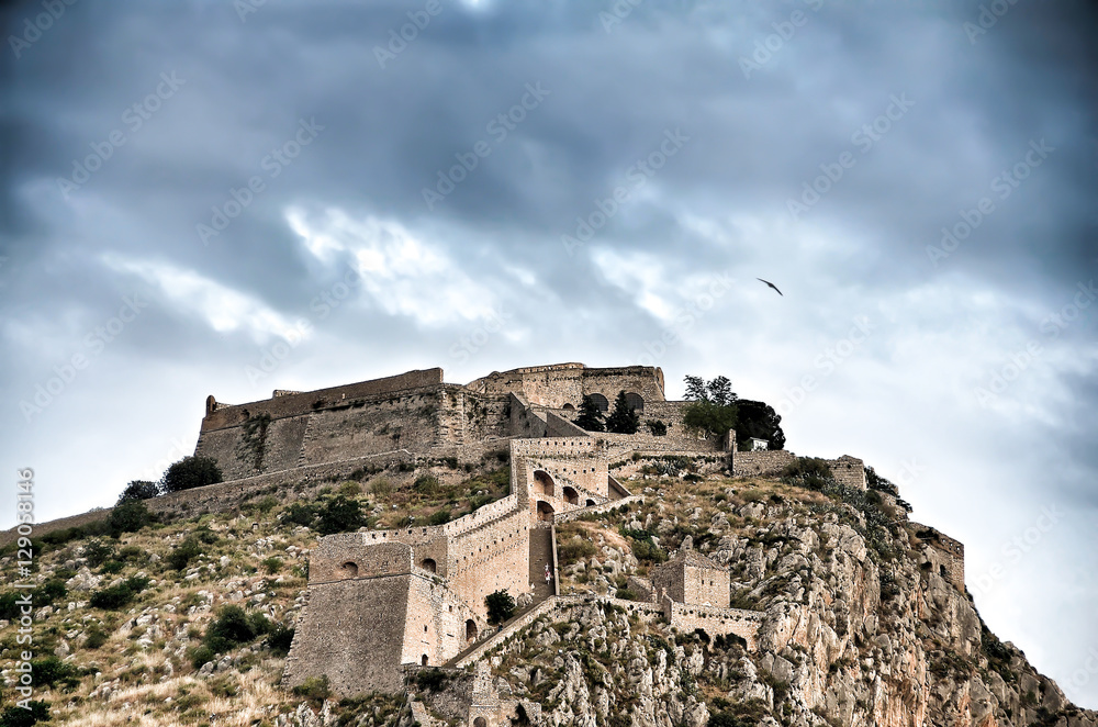 Palamidi fortress on the hill,under a cloudscape and a seagull flying above it. Nafplion - Greece