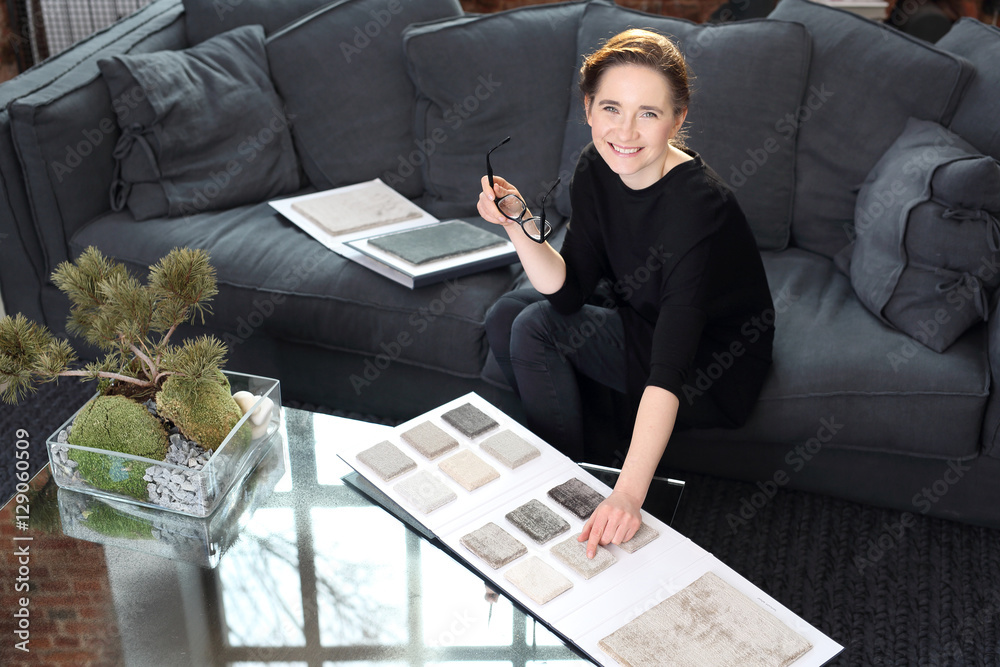 Fototapeta premium Dekorowanie wnętrz, zakupy dywanu. Kobieta wybiera wykładziną dywanową do salonu