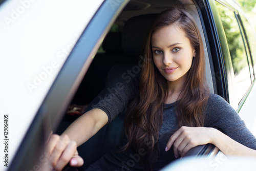 Beautiful young happy woman in car.