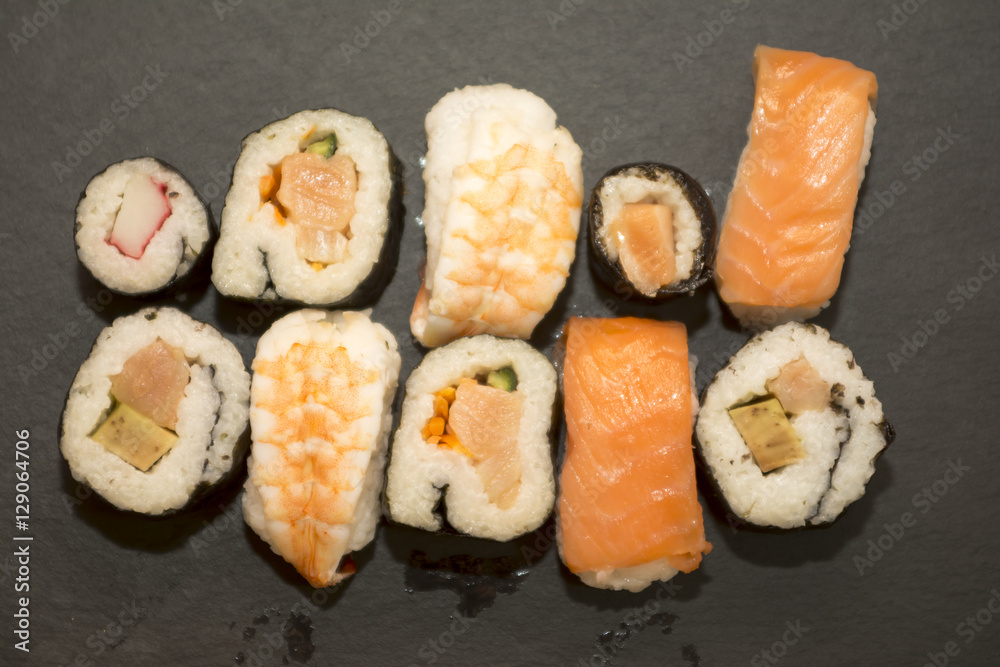 Pieces of sushi on a black stone Pieces of sushi on a black stone