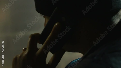 Anonymous man talking on phone in a dark room