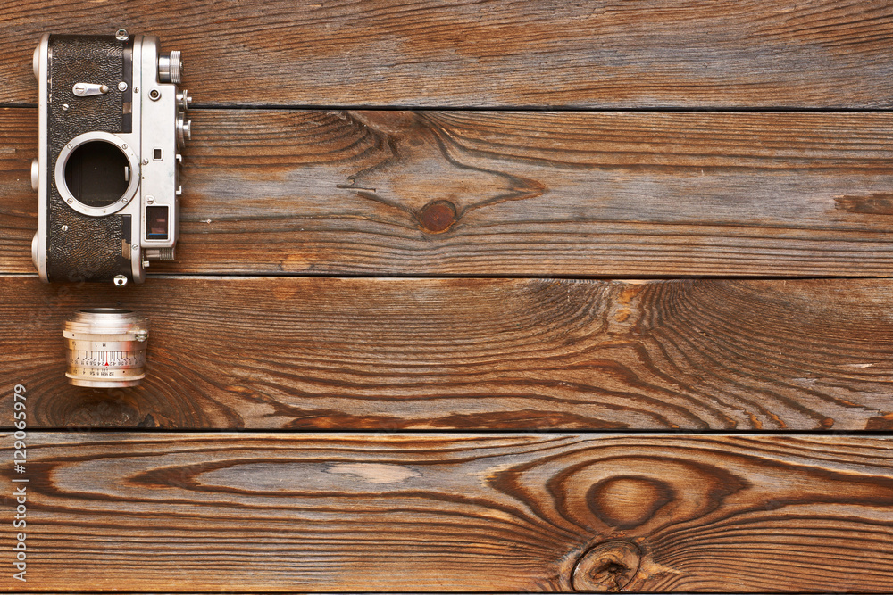 Fototapeta premium Vintage old camera and lens on wooden background