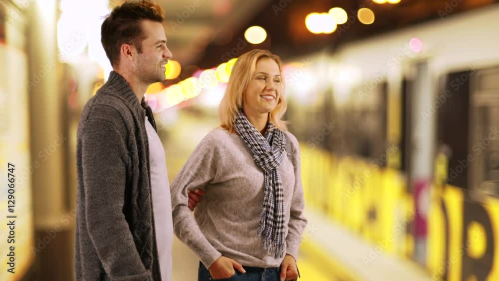 Millenial couple standing outside waiting for their train to arrive Millenial couple standing outside waiting for their train to arrive