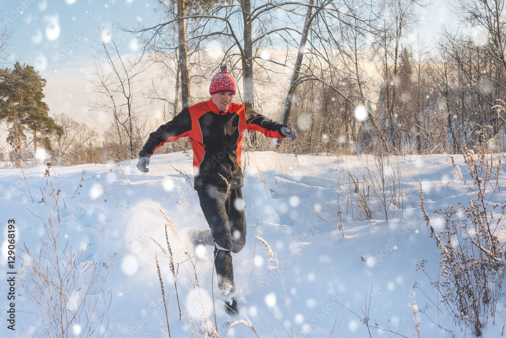 Running man in winter snowy forest. Trail running. Outdoor