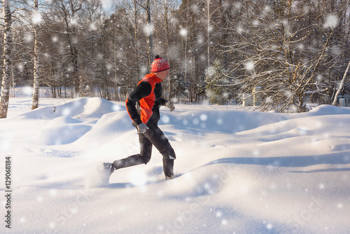 Running man in snow. Winter outdoor trail runner