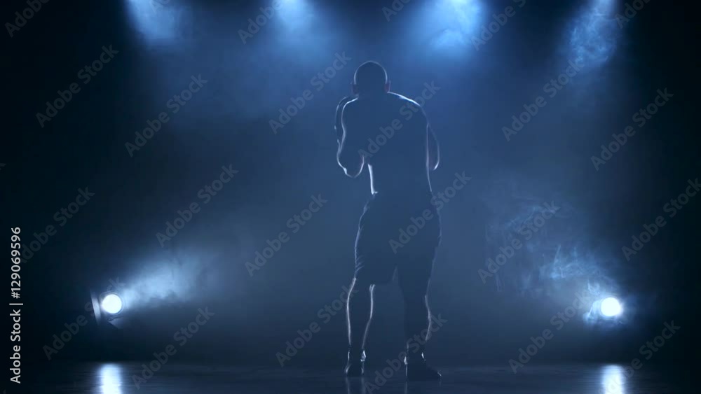 Coaching boxer male in a dark studio with rear lights Coaching boxer male in a dark studio with rear lights