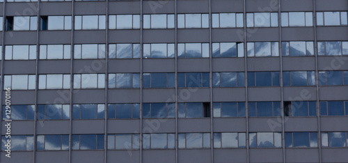 modern building windows reflecting blue sky close up
