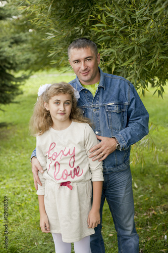 Obraz na plátne Father hugs daughter teen summer outdoors, happy family resting