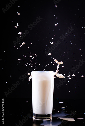 splashes of milk in a glass on a black background