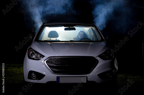 girl smoking cigarette in car full of smoke at night © dinostock