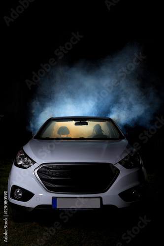 girl smoking cigarette in car full of smoke at night with gas mask