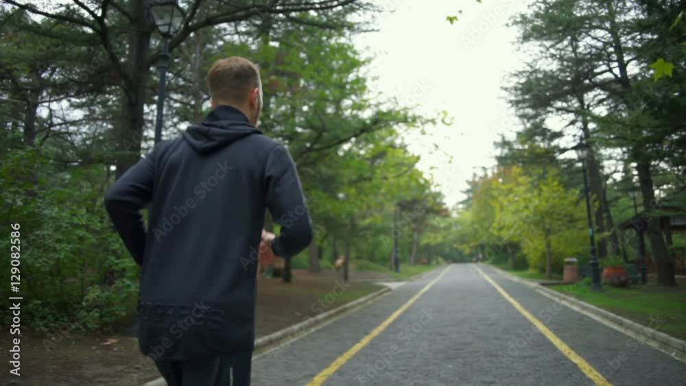Young handsome man jogging in the street slow motion Young handsome man jogging in the street slow motion