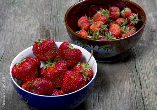 two plates with large strawberry on a table
