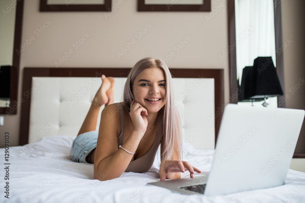 Beautiful young girl in black underwear with laptop in bed at home Beautiful young girl in black underwear with laptop in bed at home