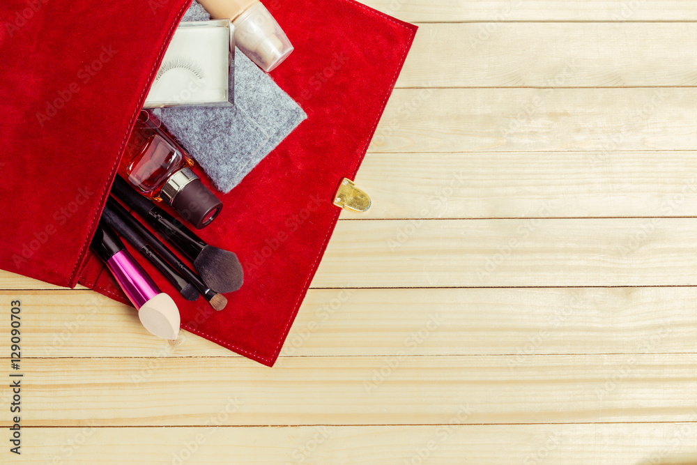 Fototapeta premium View on women bag stuff on wooden background