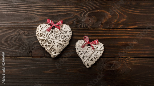 Concept of Valentine s Day. Wicker hearts on dark wooden backgro