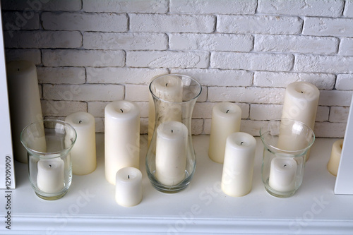 Белые свечи около кирпичной стены