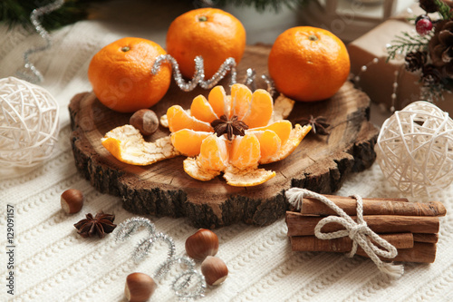 tangerines and cinnamon on the table near the Christmas tree